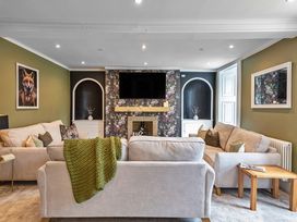 A living room with sofas, a television and a fireplace at Snowdonia Manor in Dolgellau