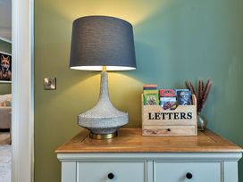 A hallway with a lamp and a wooden box labeled LETTERS at Snowdonia Manor in Dolgellau