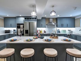 A kitchen with an island and bar stools at Snowdonia Manor in Dolgellau