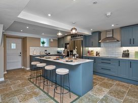 A kitchen with a bar counter and stools at Snowdonia Manor in Dolgellau