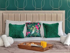 A bed with green pillows and a tray at Snowdonia Manor in Dolgellau