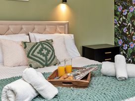 A bedroom with a bed, towels, and juice on a tray at Snowdonia Manor in Dolgellau
