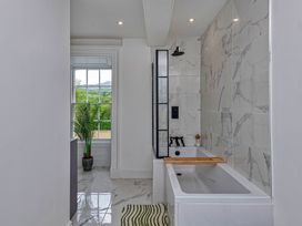 A bathroom with a bathtub and window at Snowdonia Manor in Dolgellau