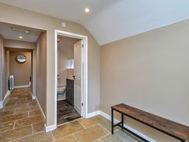 A hallway with a bench and door leading to a bathroom at Snowdonia Manor in Dolgellau