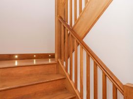 A staircase with wooden steps and handrail at Swallows Reach Halwell