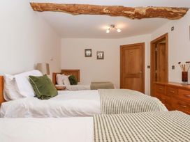 A bedroom with two beds and a wardrobe at Swallows Reach, Halwell