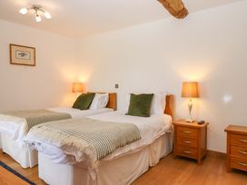 A bedroom with twin beds and nightstands at Swallows Reach in Halwell