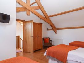 A bedroom with two beds and a wardrobe at Swallows Reach in Halwell