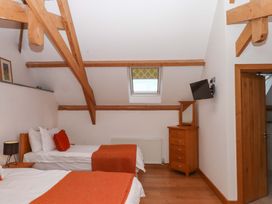 A bedroom with two beds and a television at Swallows Reach in Halwell