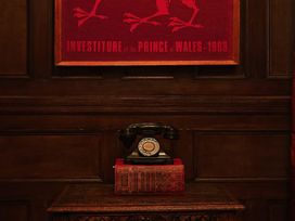 A telephone and books displayed on a cabinet at Craig y Don in Glyngarth near Llandegfan