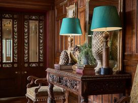 A hallway with a wooden table and lamps at Craig y Don in Glyngarth near Llandegfan