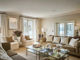 A living room with sofas and a glass table at Craig y Don in Glyngarth near Llandegfan