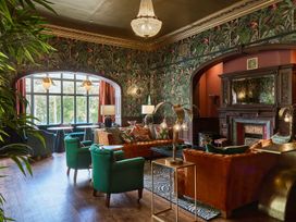 A living room with a fireplace and seating at Craig y Don in Glyngarth near Llandegfan