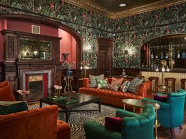 A living room with a fireplace and bar at Craig y Don in Glyngarth near Llandegfan