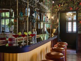 A home bar with drinks and stools at Craig y Don in Glyngarth near Llandegfan