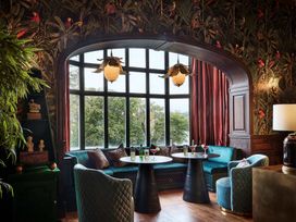 A lounge area with a window and seating at Craig y Don in Glyngarth near Llandegfan