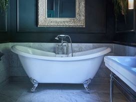 A bathroom with a white bathtub and a sink at Craig y Don Glyngarth near Llandegfan