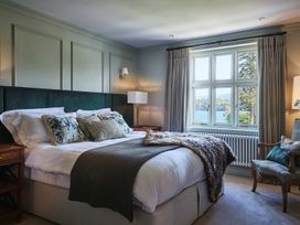 A bedroom with a bed and window at Craig y Don in Glyngarth near Llandegfan