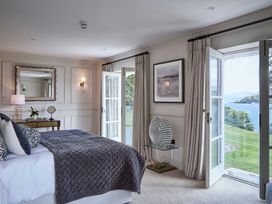 A bedroom with a bed and a table at Craig y Don in Glyngarth near Llandegfan