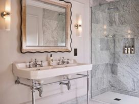 A bathroom with a double sink and shower at Craig y Don Glyngarth near Llandegfan