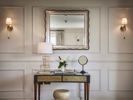 A vanity table with a mirror and flowers at Craig y Don in Glyngarth near Llandegfan