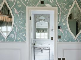 A bathroom with a sink and mirrors at Craig y Don in Glyngarth near Llandegfan