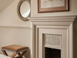 A living room with a fireplace and a mirror at Craig y Don in Glyngarth near Llandegfan