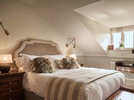 A bedroom with a bed, nightstand, and desk at Craig y Don in Glyngarth near Llandegfan