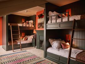 A bedroom with bunk beds and a fireplace at Craig y Don in Glyngarth near Llandegfan