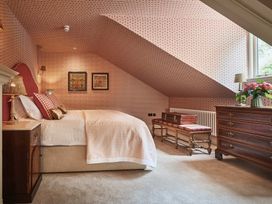 A bedroom featuring a bed, bedside lamp, and chest of drawers at Craig y Don in Glyngarth near Llandegfan