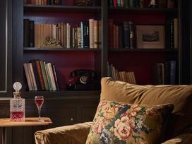 A living room with bookshelves and an armchair at Craig y Don Glyngarth near Llandegfan