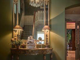 A hallway with a mirror and decorative table at Craig y Don in Glyngarth near Llandegfan