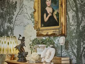 A living room featuring a painting, a sculpture and decorative items at Craig y Don in Glyngarth near Llandegfan