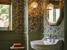A bathroom featuring a sink, mirror, and decorative items at Craig y Don Glyngarth near Llandegfan
