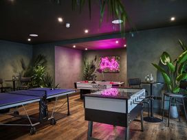 A game room with a ping pong table and foosball table at Craig y Don in Glyngarth near Llandegfan