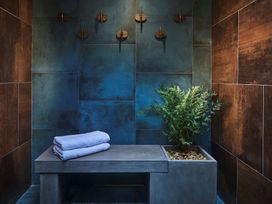 A bathroom with towels on a bench and a plant at Craig y Don in Glyngarth near Llandegfan