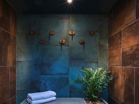 A bathroom with a towel, wall hooks, and a fern at Craig y Don, Glyngarth near Llandegfan