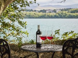 A table with wine and glasses overlooking water at Craig y Don in Glyngarth near Llandegfan