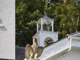 A clock tower with a bell and a statue at Craig y Don in Glyngarth near Llandegfan