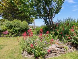 A garden with flowers and a tree at Bramble Cottage in Gwithian near Connor Downs