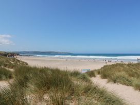 A beach view with grass and water at Bramble Cottage in Gwithian near Connor Downs