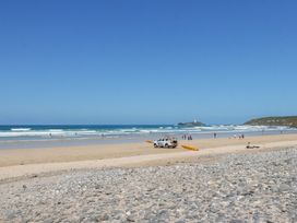 A beach scene with people and a lifeguard vehicle at Bramble Cottage in Gwithian near Connor Downs