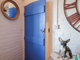 An entryway with a blue door and a dog statue at The Clock Tower in Rousdon, Nr Lyme Regis