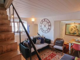 A living room with a sofa, clock, and artwork at The Clock Tower, Rousdon, Nr Lyme Regis