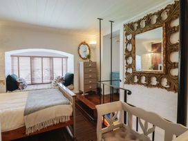 A bedroom with a bed and window seating at The Clock Tower in Rousdon, Nr Lyme Regis