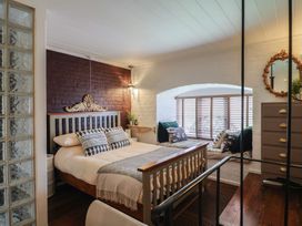 A bedroom with a bed and a window with blinds at The Clock Tower in Rousdon, Nr Lyme Regis