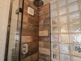 A shower with wooden tiles and glass block wall at The Clock Tower in Rousdon, Nr Lyme Regis