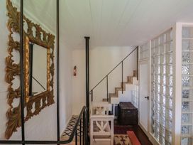 A hallway with a staircase and a glass block wall at The Clock Tower in Rousdon, Nr Lyme Regis