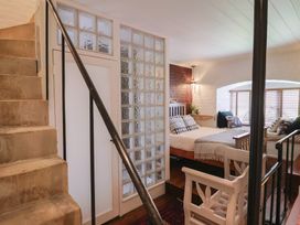 A bedroom with a bed and glass block wall at The Clock Tower Rousdon, Nr Lyme Regis