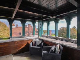 A balcony with chairs overlooking the sea at The Clock Tower in Rousdon, Nr Lyme Regis